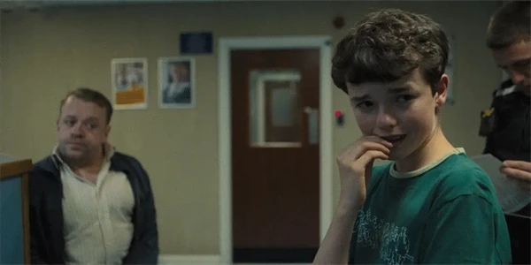 A boy in a green shirt looks uneasy in "Adolescence".