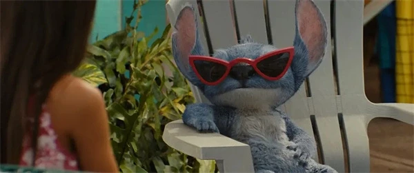Stitch wearing red sunglasses in "Lilo & Stitch", relaxing on a chair.