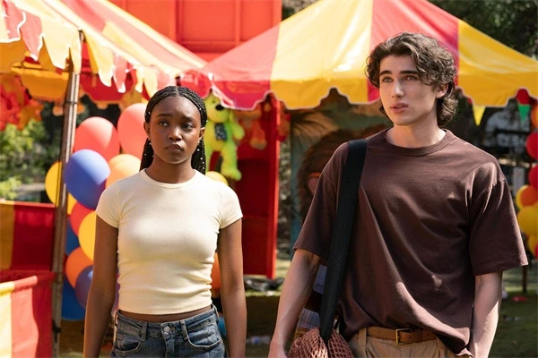 A young couple stands amidst a colorful fair in "Paradise".