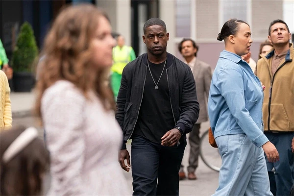Xavier walks through a crowd, looking cautious in "Paradise".