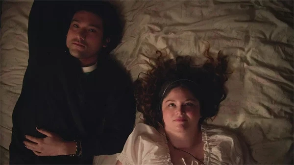 A couple lies in bed, looking contemplative in "Too Much".