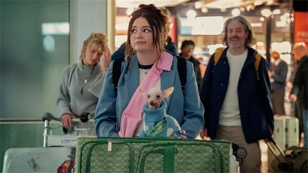 A woman with a small dog at the airport in "Too Much".
